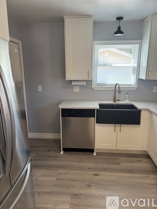 A kitchen with a stainless steel refrigerator and a black dishwasher.