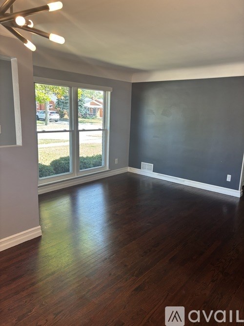A room with wooden floors and a large window.