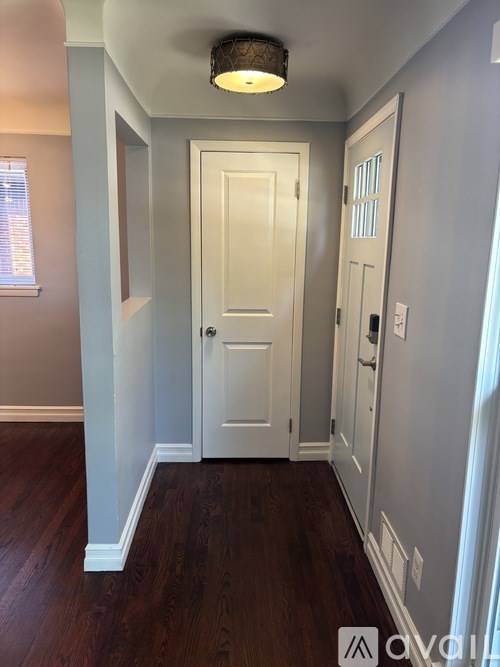 A hallway with a white door and a light on the ceiling.