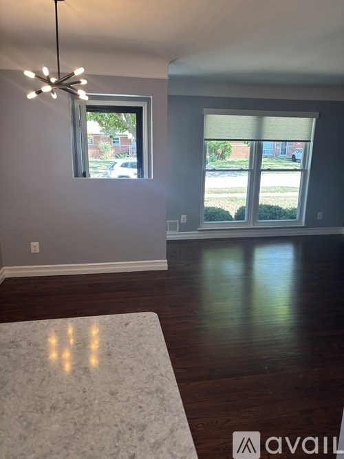 A room with a large rug and a chandelier.