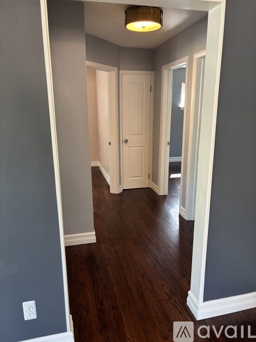 A hallway with a light on and a door at the end.