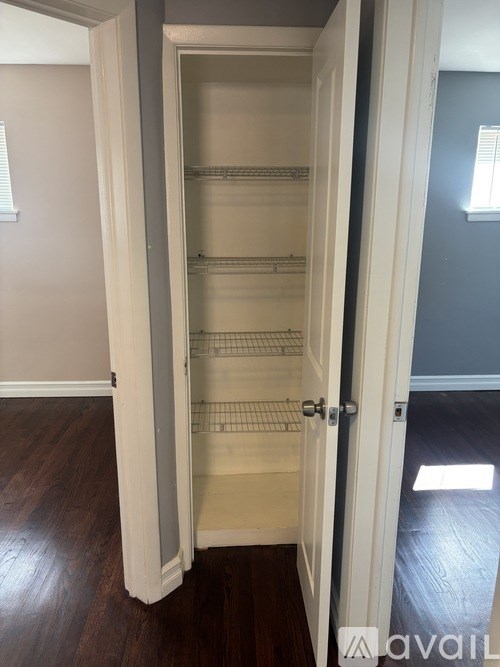 A white closet with shelves and a door open.