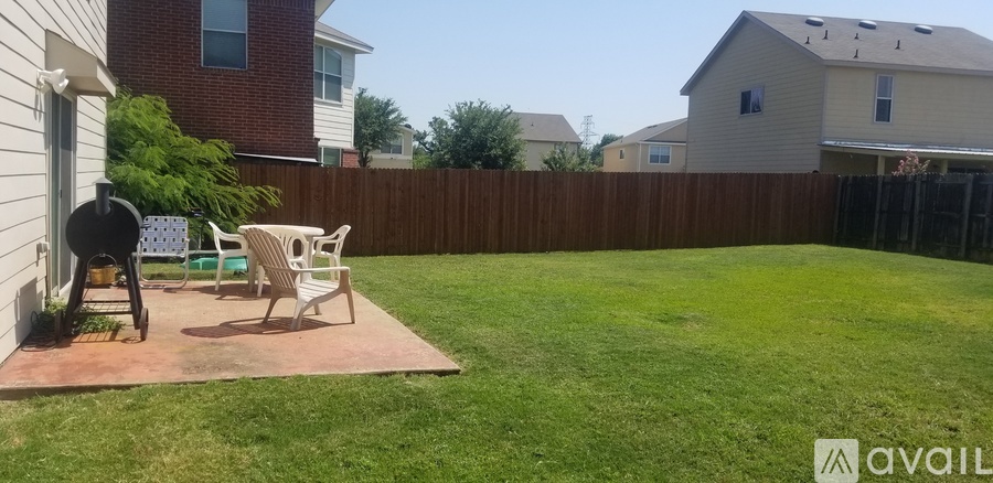 A backyard with a patio table and chairs.