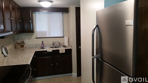 A kitchen with a refrigerator and a sink.