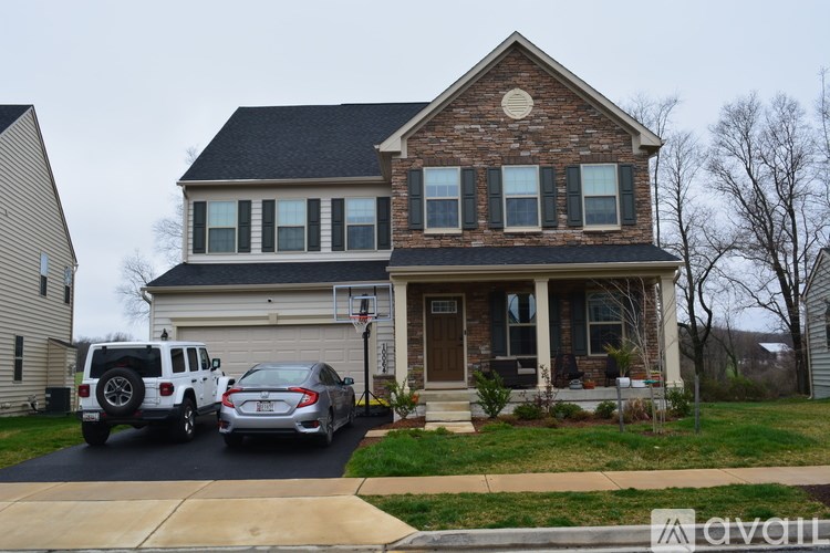 A house with a car and a jeep parked in front.