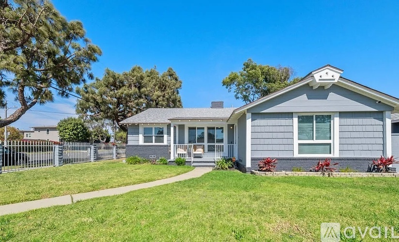 A house with a grey roof and white trim is for sale.