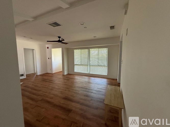 A room with wooden flooring and a ceiling fan.