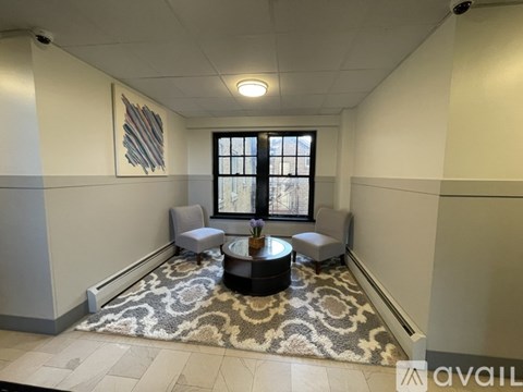 A living room with a rug, a coffee table, and a window.
