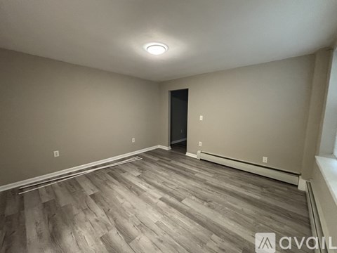 A room with wooden flooring and a black door.