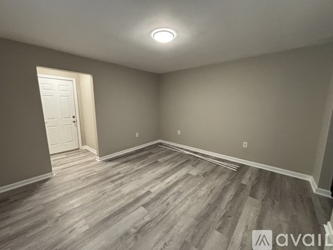 A room with wooden flooring and a white door.