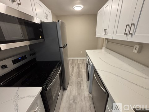 A kitchen with a black fridge and stove top oven.