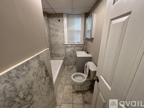 A bathroom with a marble counter top and a toilet.