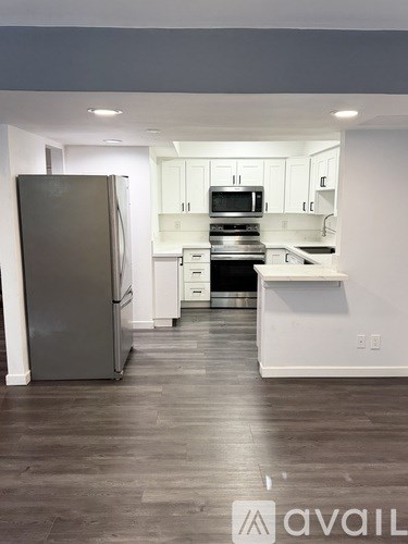 A kitchen with a refrigerator, oven, and microwave.