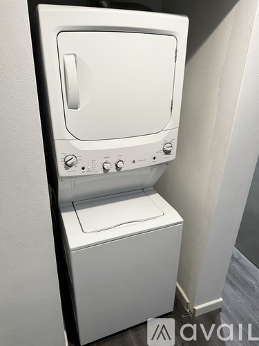 A white washing machine is installed in a bathroom.