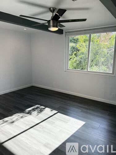 A room with a ceiling fan and a window.