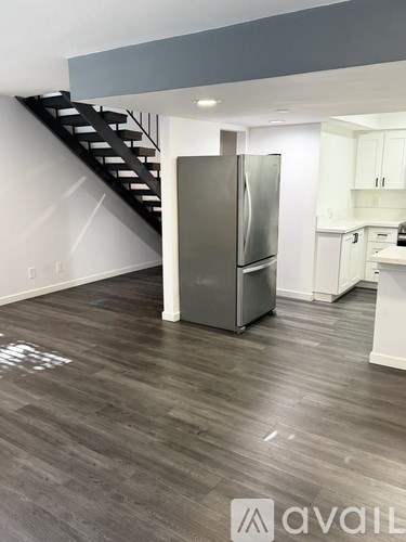 A kitchen with a refrigerator and a staircase.
