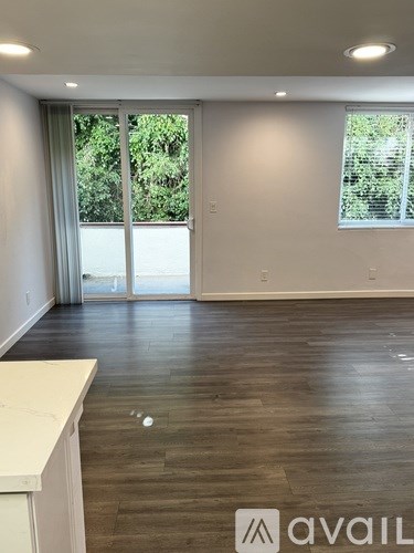 A room with a white counter and a window with a view of trees.