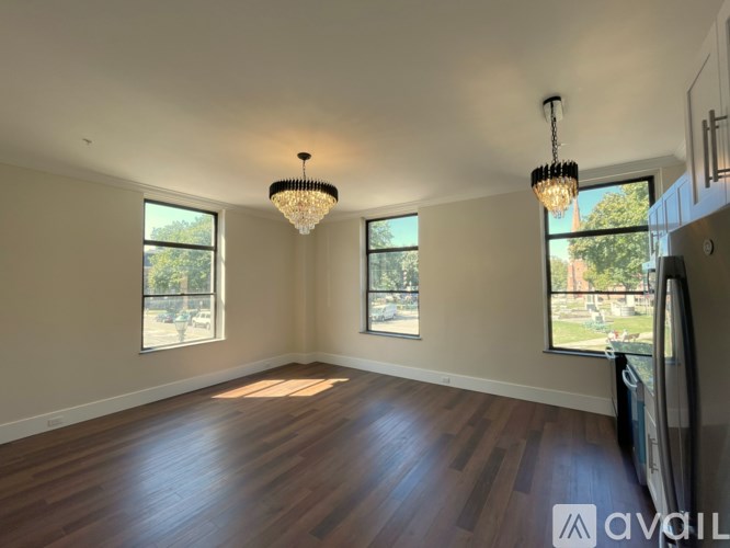A room with wooden floors and a chandelier hanging from the ceiling.