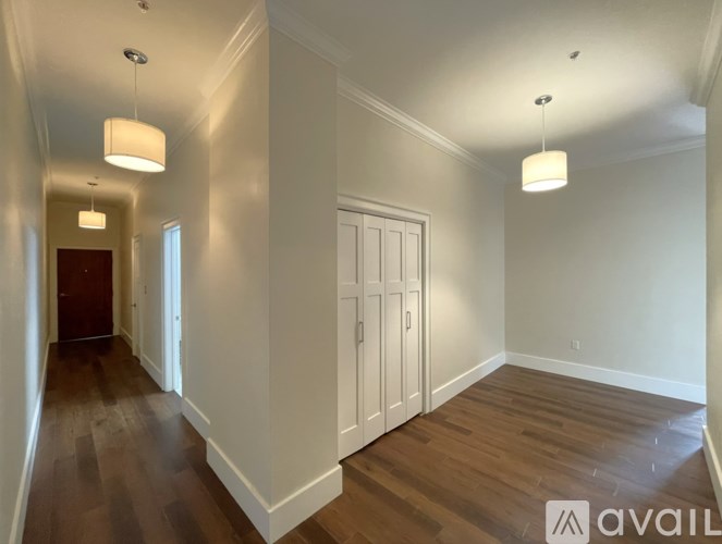A long hallway with wood floors and white walls.