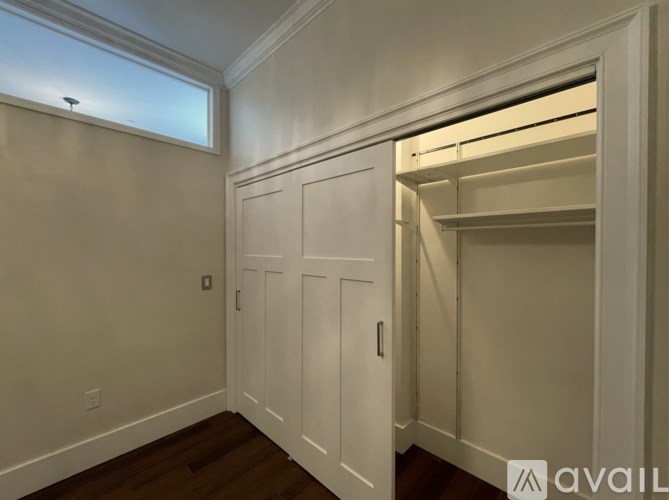 A white closet with a window above it.