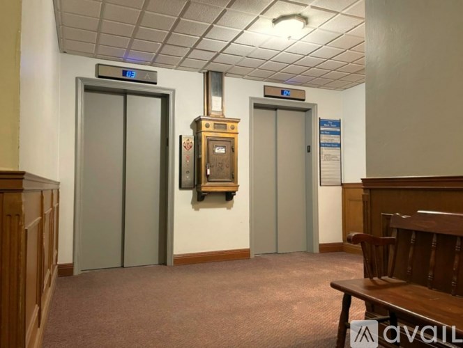 A room with two doors, one of which is open, and a bench.