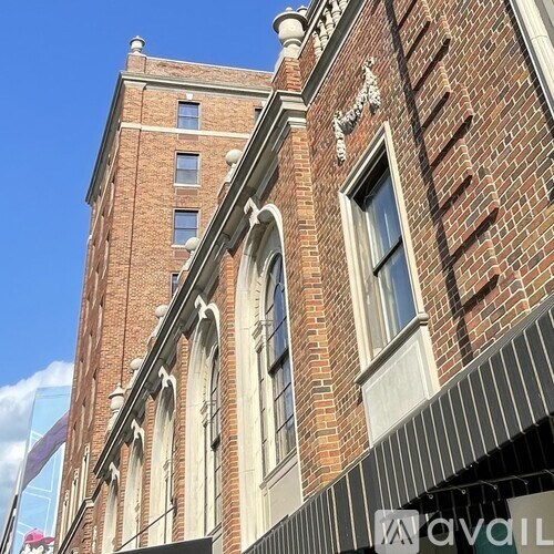 A tall red brick building with white trim and windows.