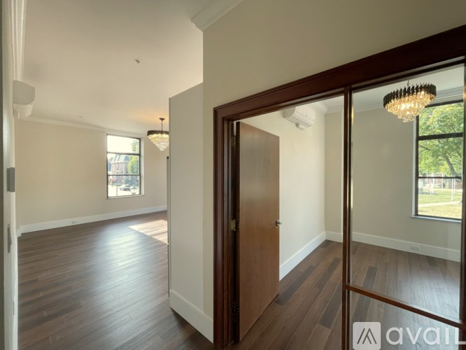 A room with wooden floors and a chandelier hanging from the ceiling.