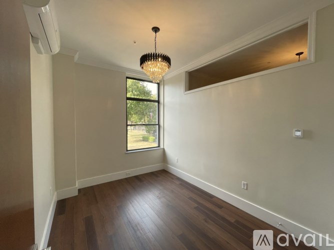 A room with a chandelier and a window.