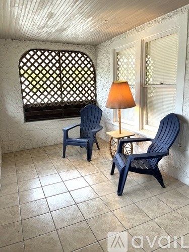 Two chairs and a table with a lamp on it.