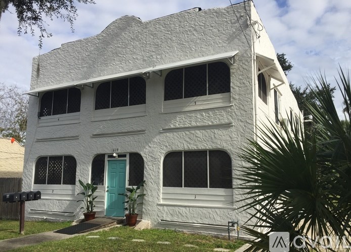 A white house with a blue door and windows.