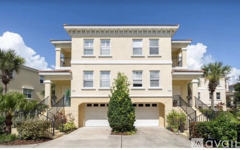 A two-story house with a garage and a tree in front.
