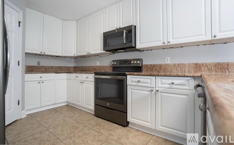 A kitchen with white cabinets and a black oven.