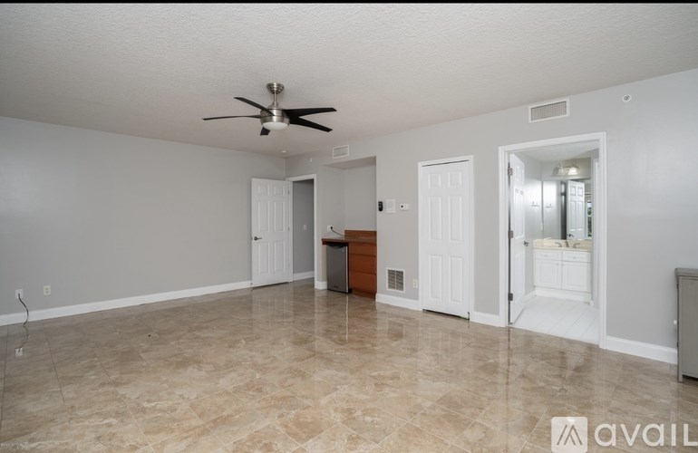 A spacious room with a ceiling fan and tiled flooring.