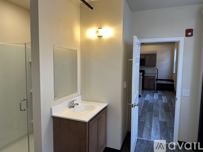 A bathroom with a sink, mirror, and shower.