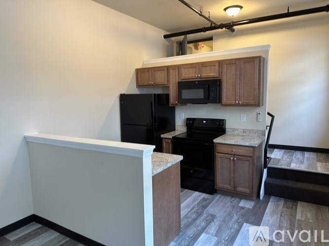 A kitchen with black appliances and wooden cabinets.
