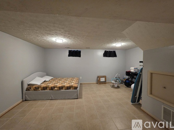 A bedroom with a bed, a chair, and a table.