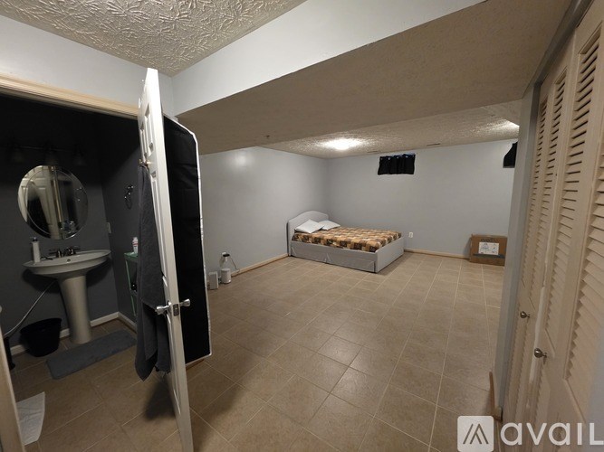 A room with a bed, sink, and toiletries.