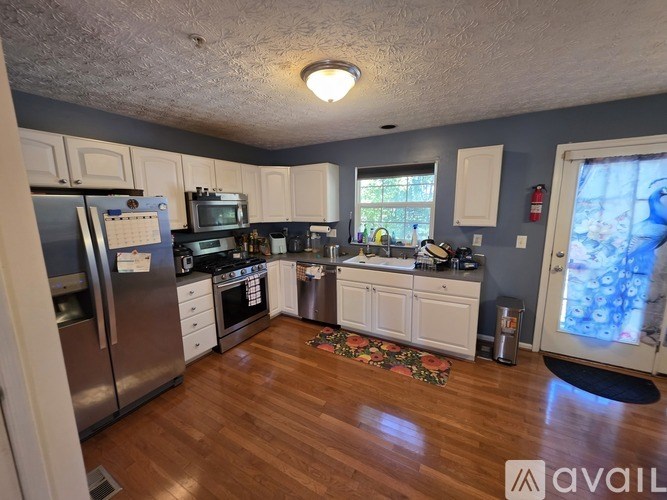A kitchen with wooden floors and white cabinets.