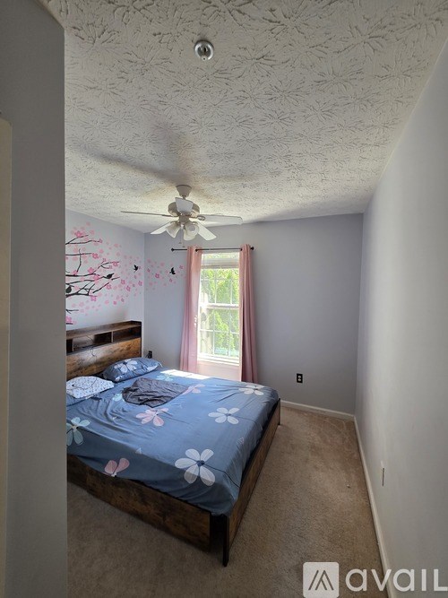 A bedroom with a bed and a ceiling fan.