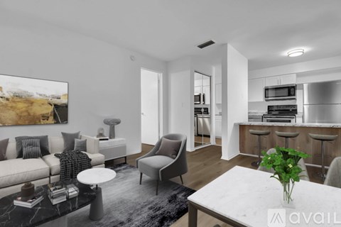A modern living room with a grey sofa, a white coffee table, and a large painting on the wall.