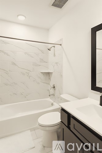 A bathroom with a marble patterned shower wall.