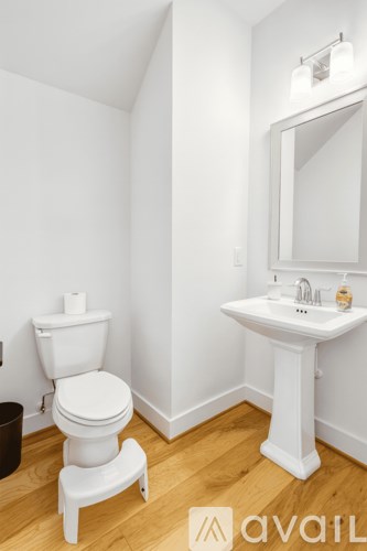 A white toilet and sink in a small bathroom.