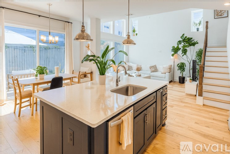 A modern kitchen with a large island and pendant lights.