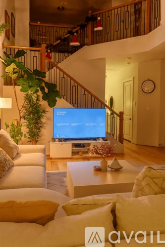 A living room with a television and a staircase.