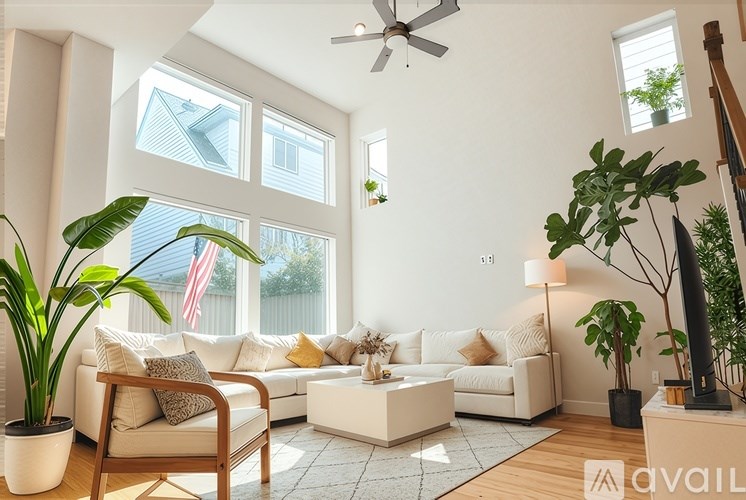 A living room with a white couch, a chair, a coffee table, and a plant.