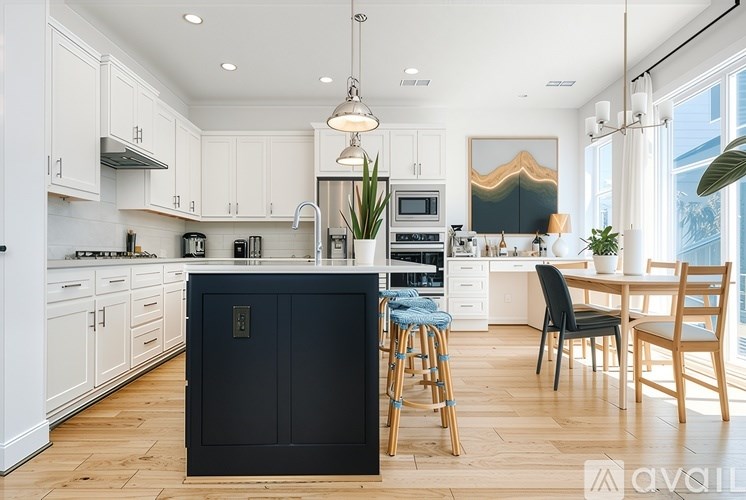 A kitchen with white cabinets and a black island.