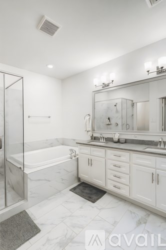 A bathroom with a marble floor and white walls.