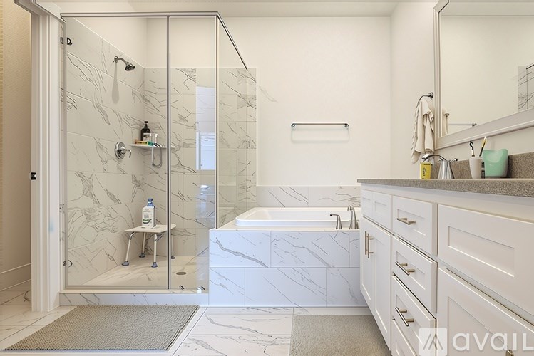 A bathroom with a marble shower and a glass door.
