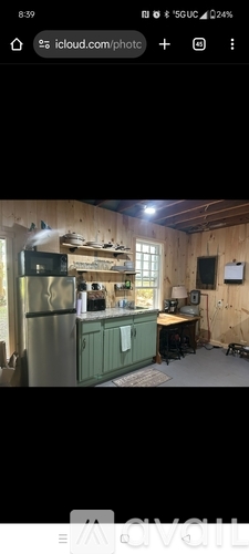 A kitchen with wooden walls and a green fridge.