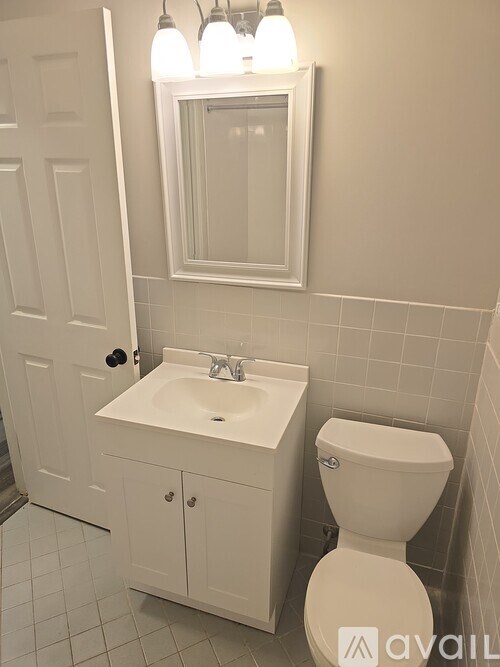 A white bathroom with a toilet, sink, and medicine cabinet.